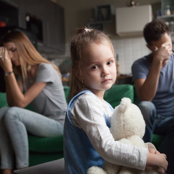 Picture of a sad child with parents in the background with their heads in their hands due to their separation.