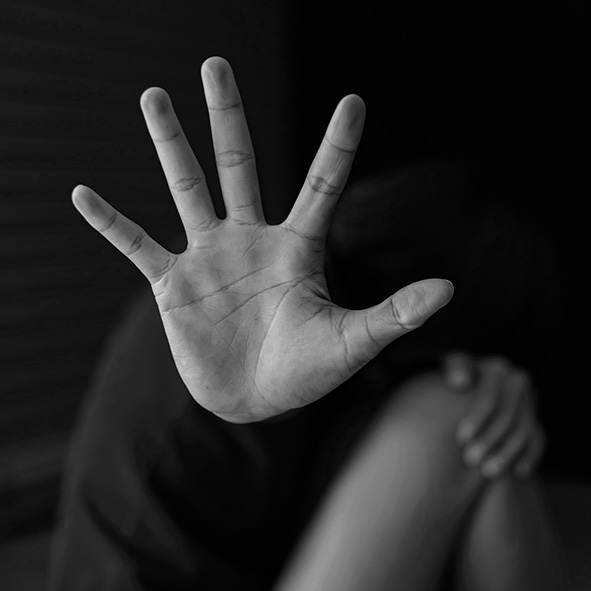 Black and White Picture showing a female cowering away with her hand up in defence.