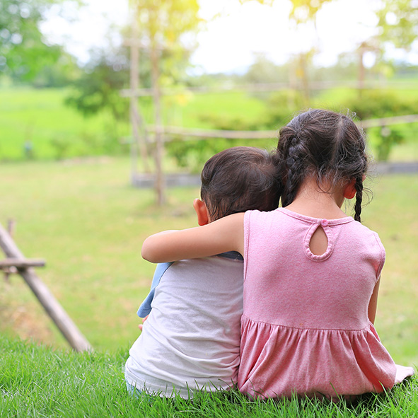 Two young children embracing.