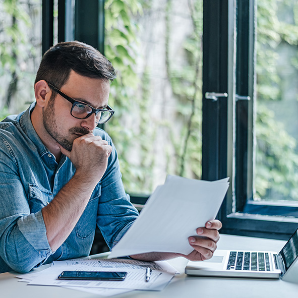 Man sitting at desk reading important documents.