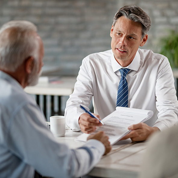 Business man speaking with elderly man.