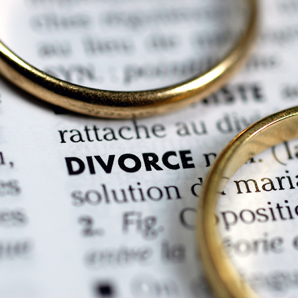 wedding rings sitting on piece of paper with the definition of divorce printed on it