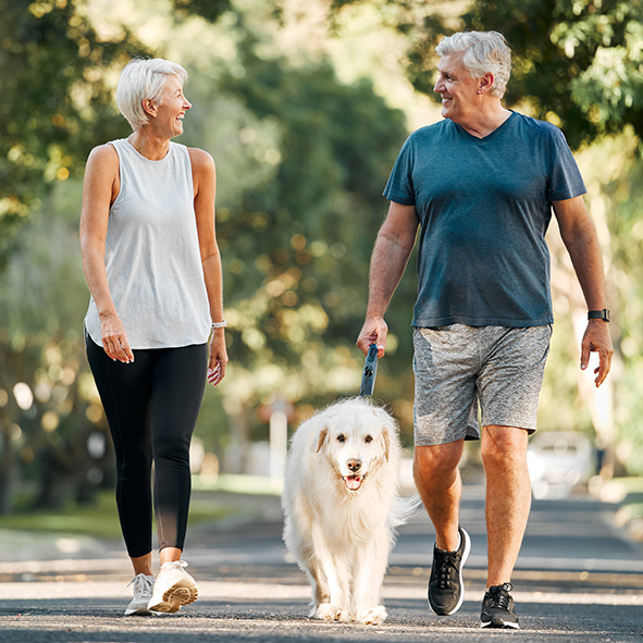 elderly couple on a walk with dog