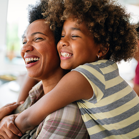 Mother and son hugging and smiling.