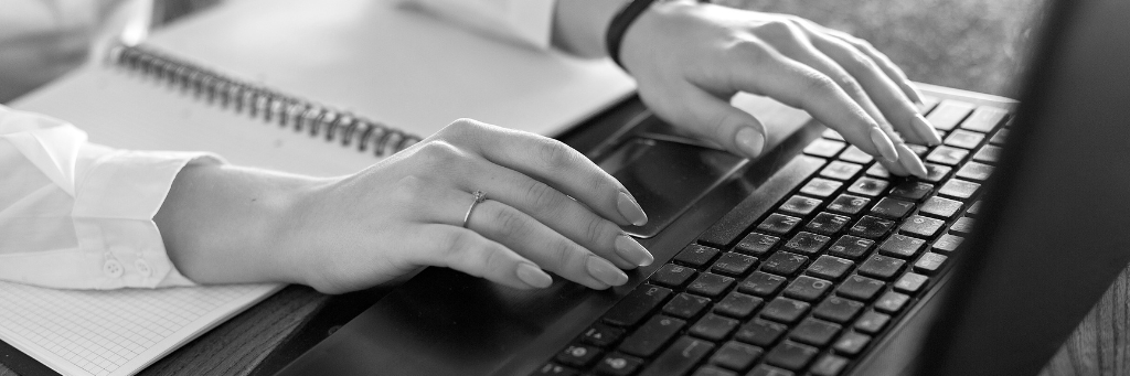 Picture of a person typing on a laptop using the Contact Us feature of a website.