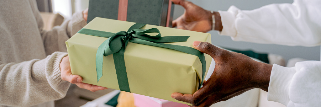 Picture showing one person giving a gift to another person.