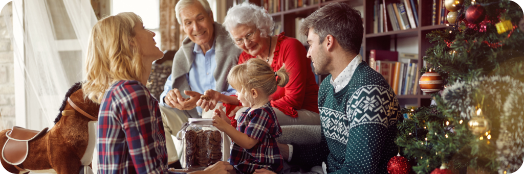 A family at Christmas gathered around the tree exchanging presents.