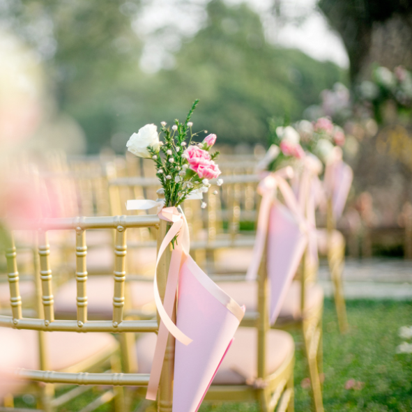 Picture of chairs and pink flowers laid out in preparation for a wedding ceremony