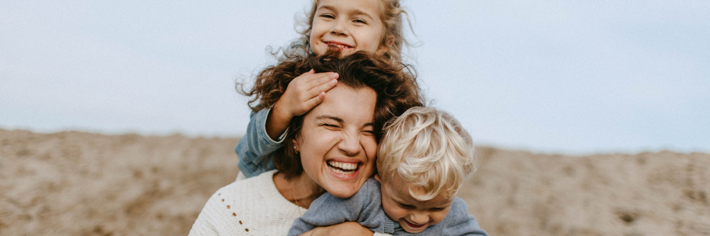 Picture of happy mother and children playing and having fun at the beach.