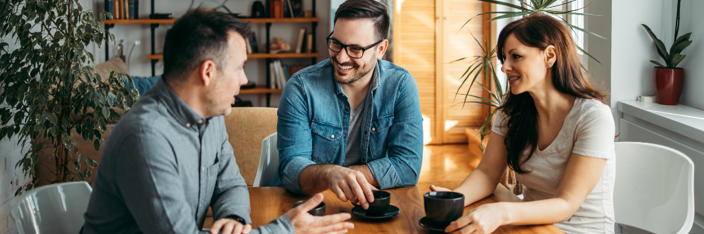 Picture of three people having a meeting.