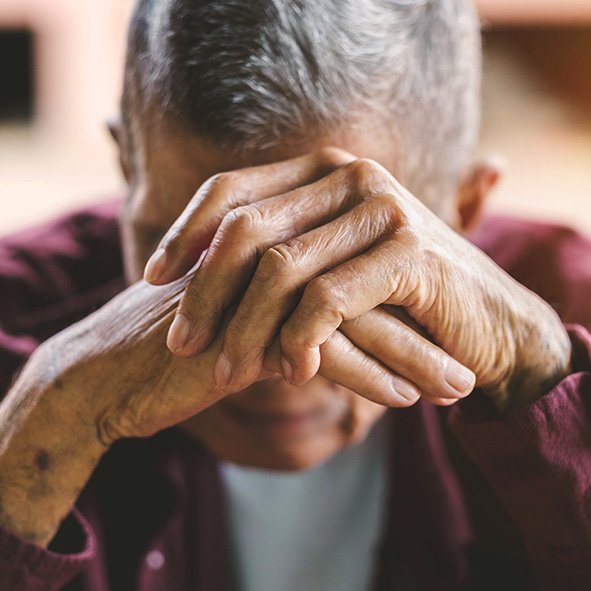 elderly man with his head in his hands