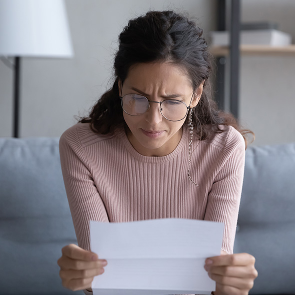 Lady looking concerned whilst reading paperwork